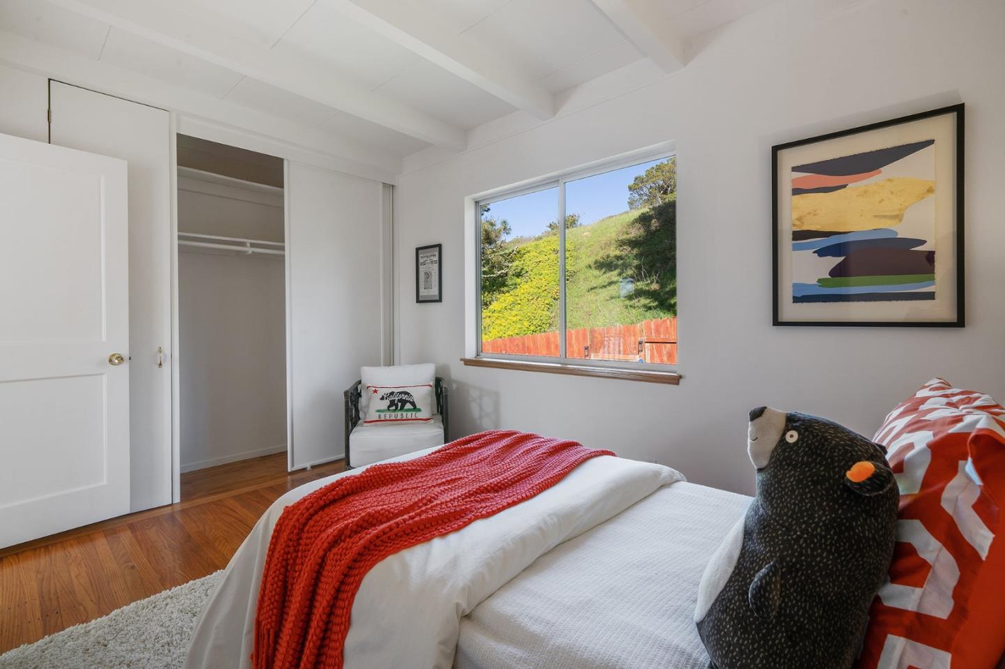 559 Manor Drive Pacifica, CA 94044 - Photo 27 of 38 a bedroom with a bed and a painting on the wall