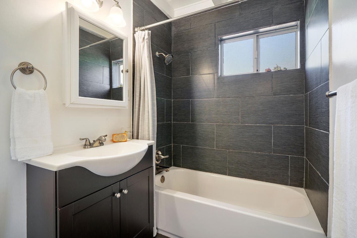 559 Manor Drive Pacifica, CA 94044 - Photo 29 of 38 a bathroom with a bathtub sink vanity and mirror