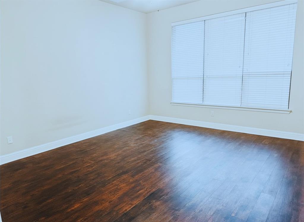 5709 Ridgepass Lane McKinney, TX 75071 - Photo 13 of 19 Spacious room featuring wood-finish flooring, white baseboards, and neutral wall tones