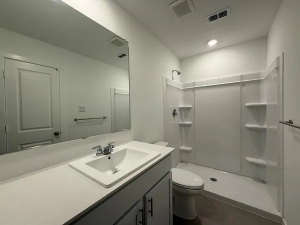 a bathroom with a sink a toilet and shower