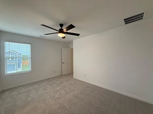 an empty room with a window and a fan