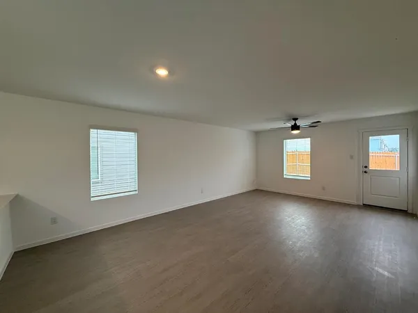 an empty room with a window and a fan