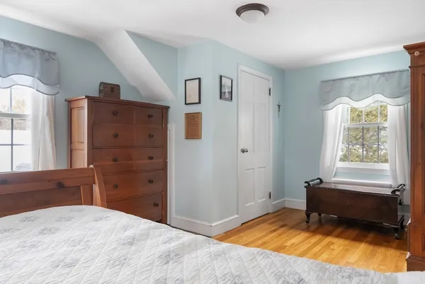 a bedroom with a bed a table and windows