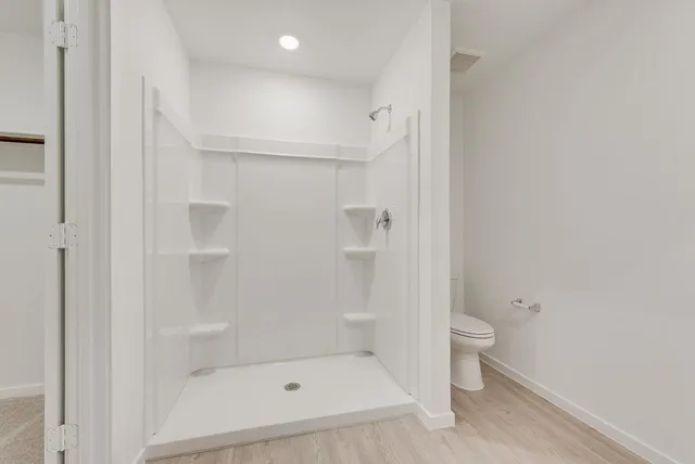 a bathroom with a shower a toilet and a sink