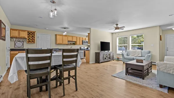 a view of a livingroom with furniture a flat screen tv and wooden floor