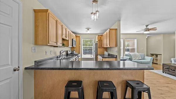 a kitchen with stainless steel appliances granite countertop a sink a stove counter space and dining table