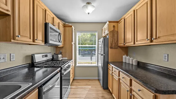 a kitchen with stainless steel appliances granite countertop a sink stove and cabinets