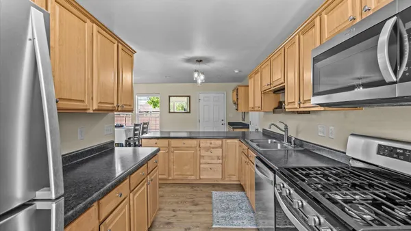 a kitchen with stainless steel appliances granite countertop a sink stove and refrigerator