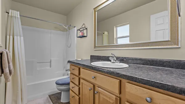a bathroom with a granite countertop sink toilet and shower
