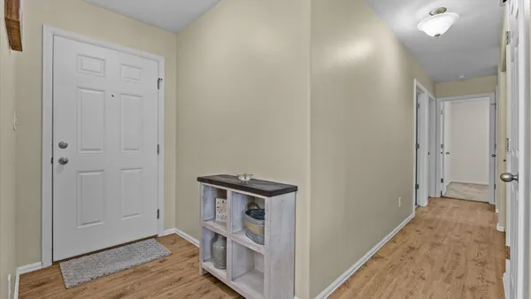 a view of a hallway with wooden floor and closet