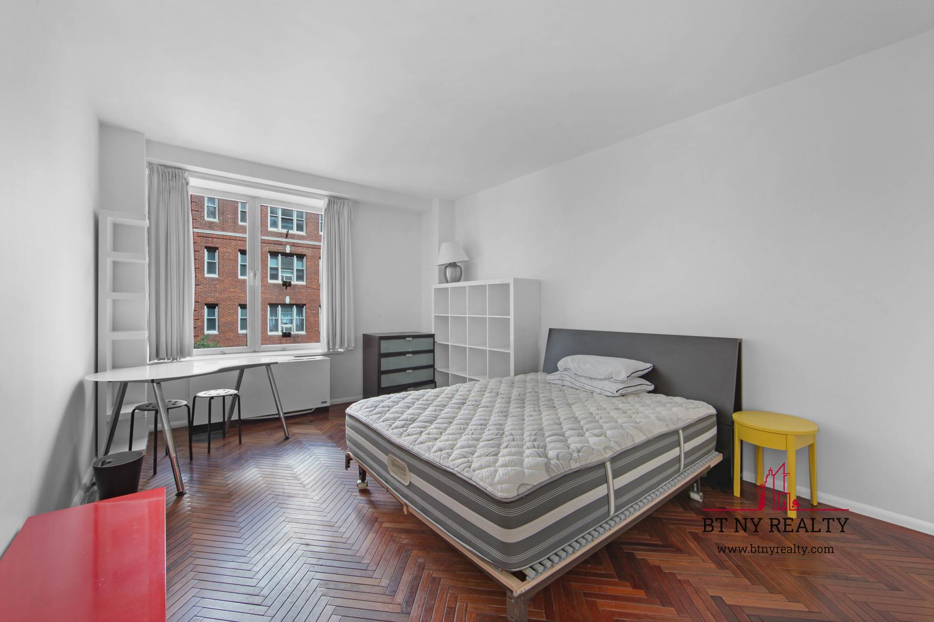 216-218 East 47th Street, Unit 4A Manhattan, NY 10017 - Photo 8 of 10 a bedroom with a bed and wooden floor