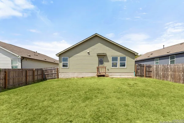 a view of a backyard with wooden fence