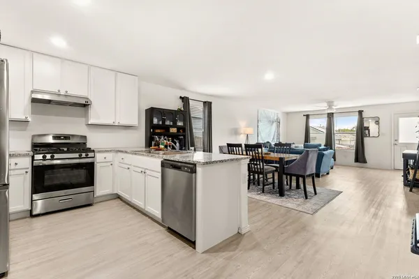 a kitchen with stainless steel appliances granite countertop a refrigerator a stove and a sink