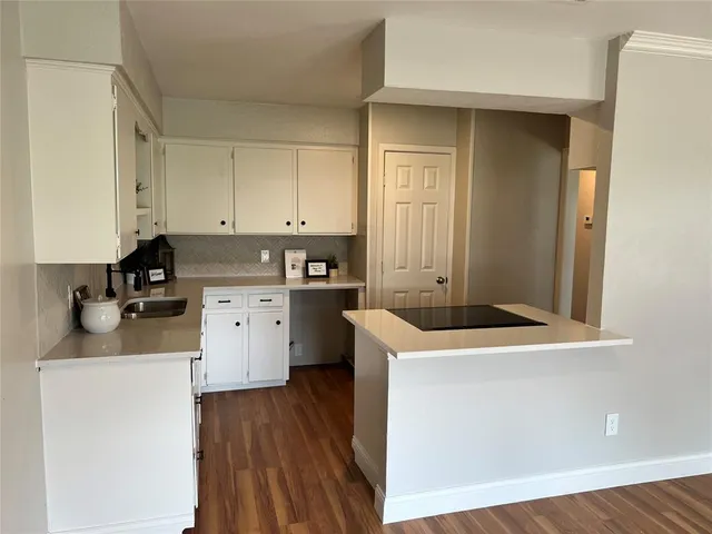 a room with a sink a stove and cabinets