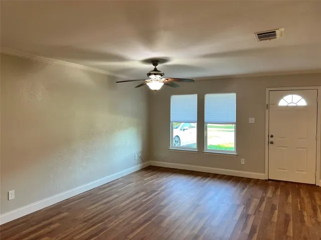 a view of a room with wooden floor and a window