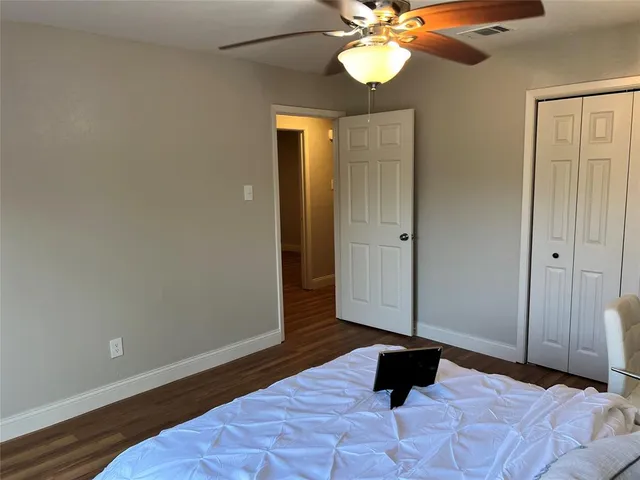 a view of a livingroom with a chandelier fan and wooden floor