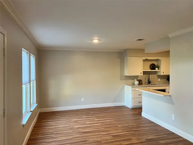 a view of a kitchen with wooden floor and a sink