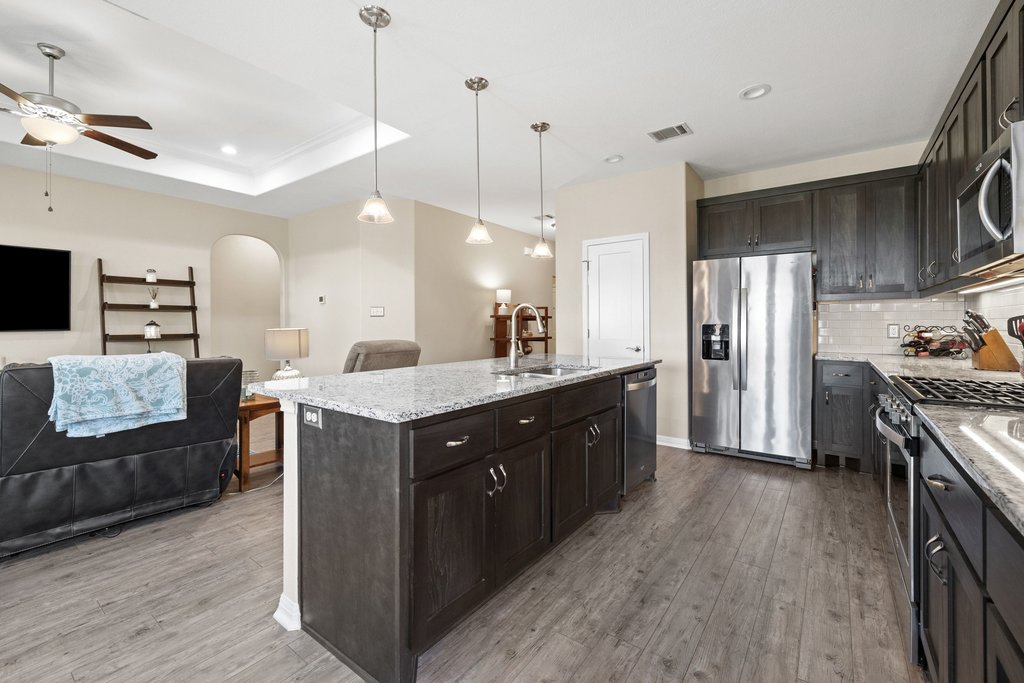 1720 Prather Street Taylor, TX 76574 - Photo 11 of 34 a kitchen with stainless steel appliances granite countertop a refrigerator a sink dishwasher a oven and a dining table with wooden floor