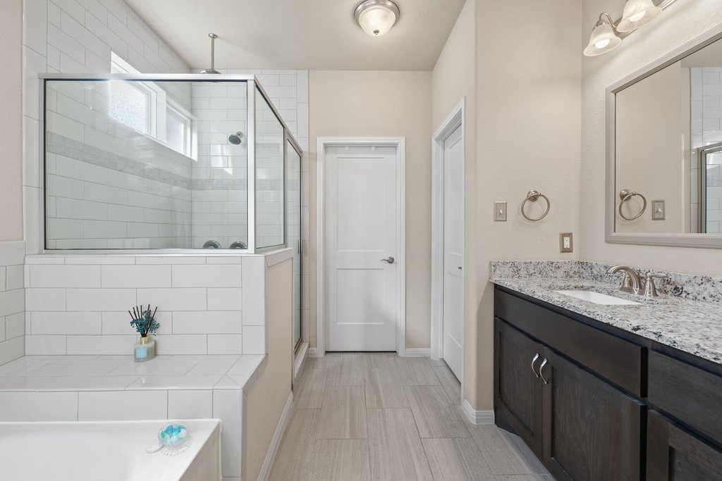 1720 Prather Street Taylor, TX 76574 - Photo 18 of 34 a bathroom with a granite countertop shower sink and mirror