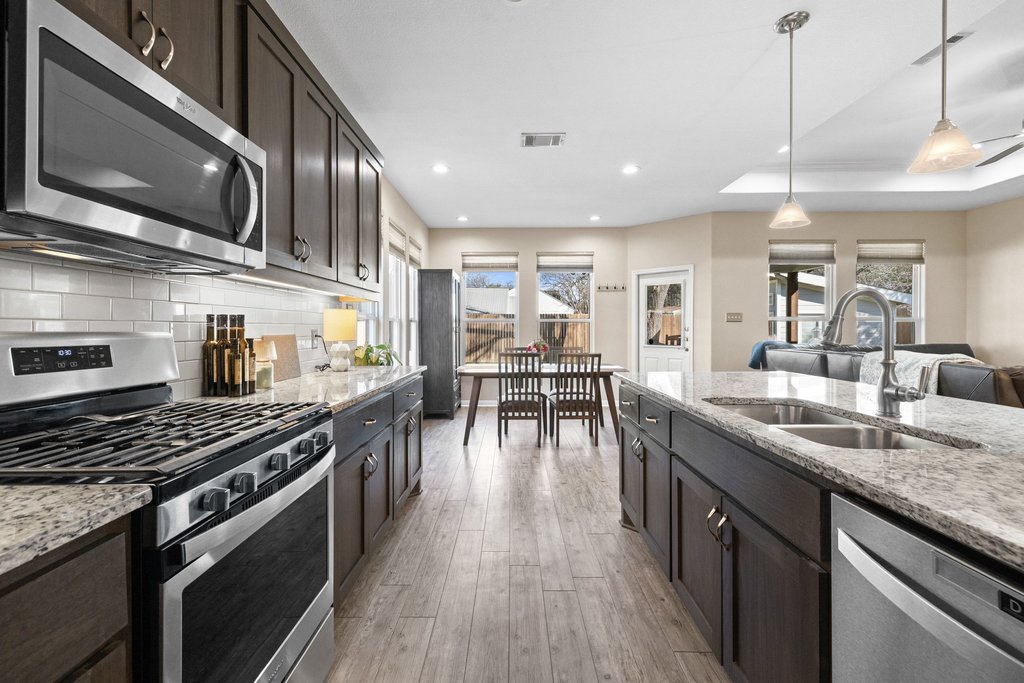 1720 Prather Street Taylor, TX 76574 - Photo 9 of 34 a kitchen with stainless steel appliances granite countertop lots of counter top space a stove and a wooden floors