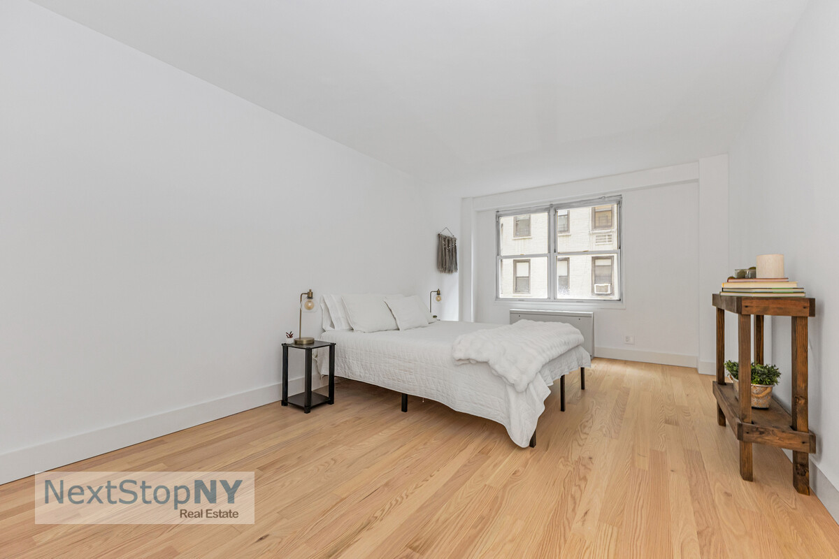 363 East 76th Street, Unit 2L Manhattan, NY 10021 - Photo 6 of 10 a bedroom with a bed and wooden floor