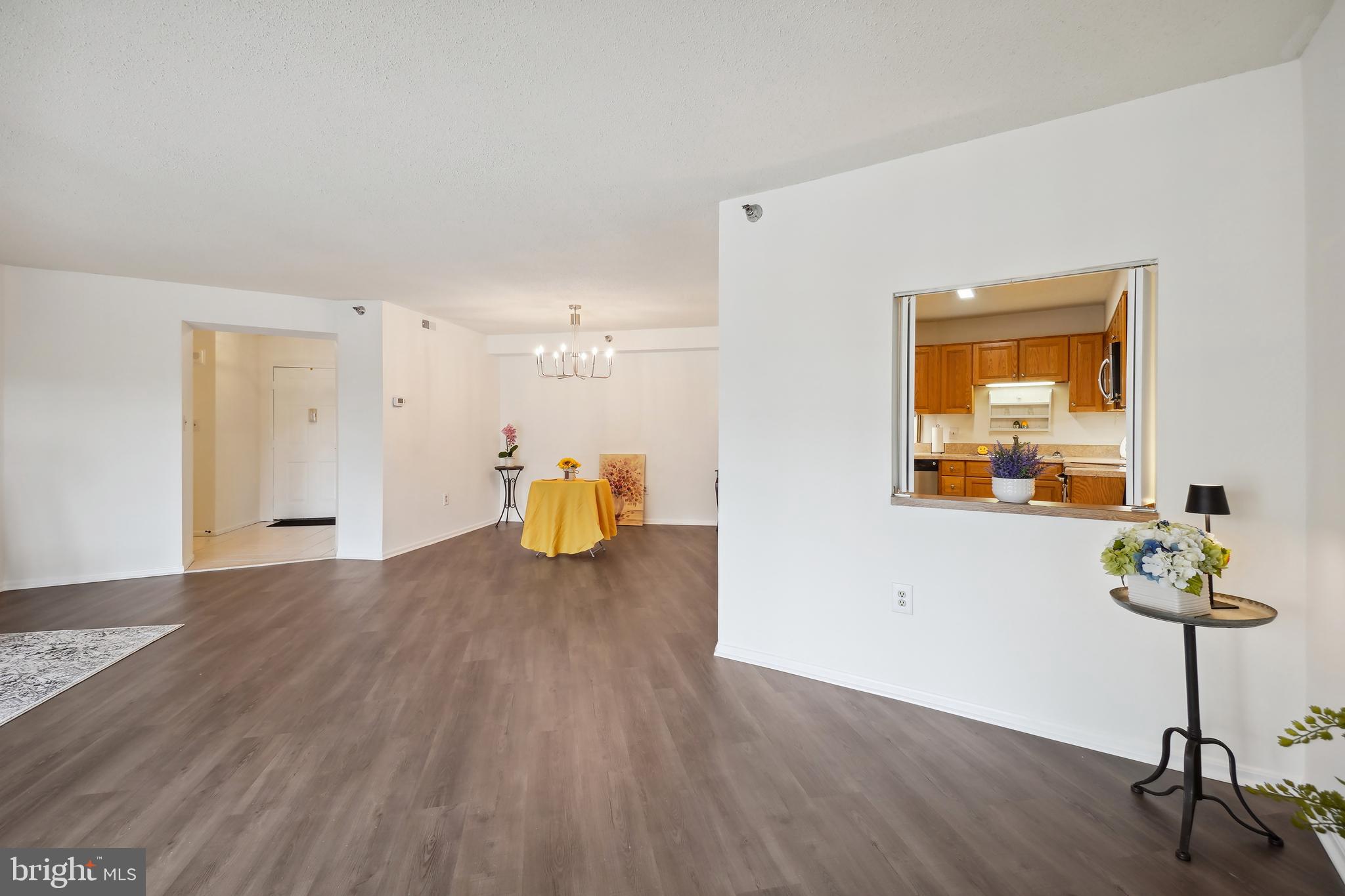 15100 Interlachen Drive, Unit 4517 Silver Spring, MD 20906 - Photo 14 of 42 a living room with wooden floor and a table chair