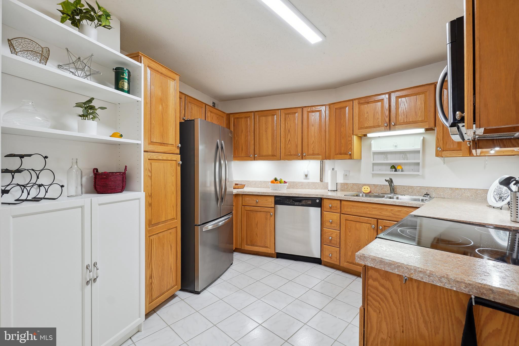 15100 Interlachen Drive, Unit 4517 Silver Spring, MD 20906 - Photo 5 of 42 a kitchen with granite countertop a refrigerator stove top oven and sink