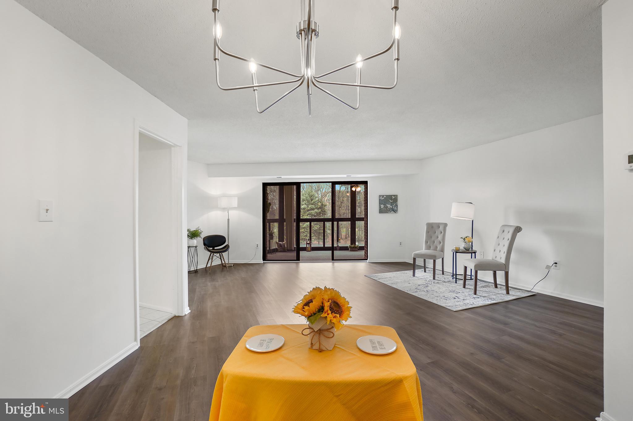 15100 Interlachen Drive, Unit 4517 Silver Spring, MD 20906 - Photo 9 of 42 a living room with dining table and wooden floor