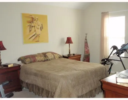a bedroom with a bed and painting on the wall