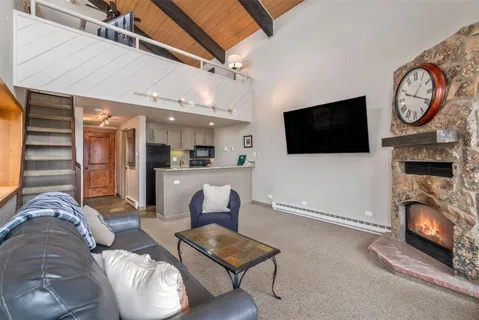 a living room with furniture a flat screen tv and a fireplace