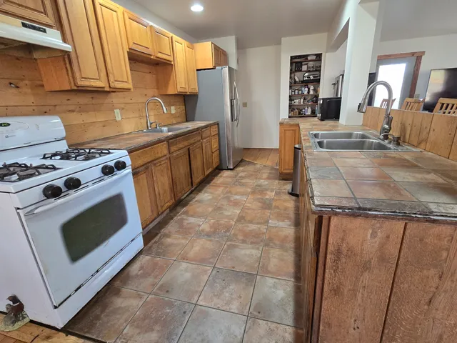 a living room with furniture a flat screen tv and kitchen view