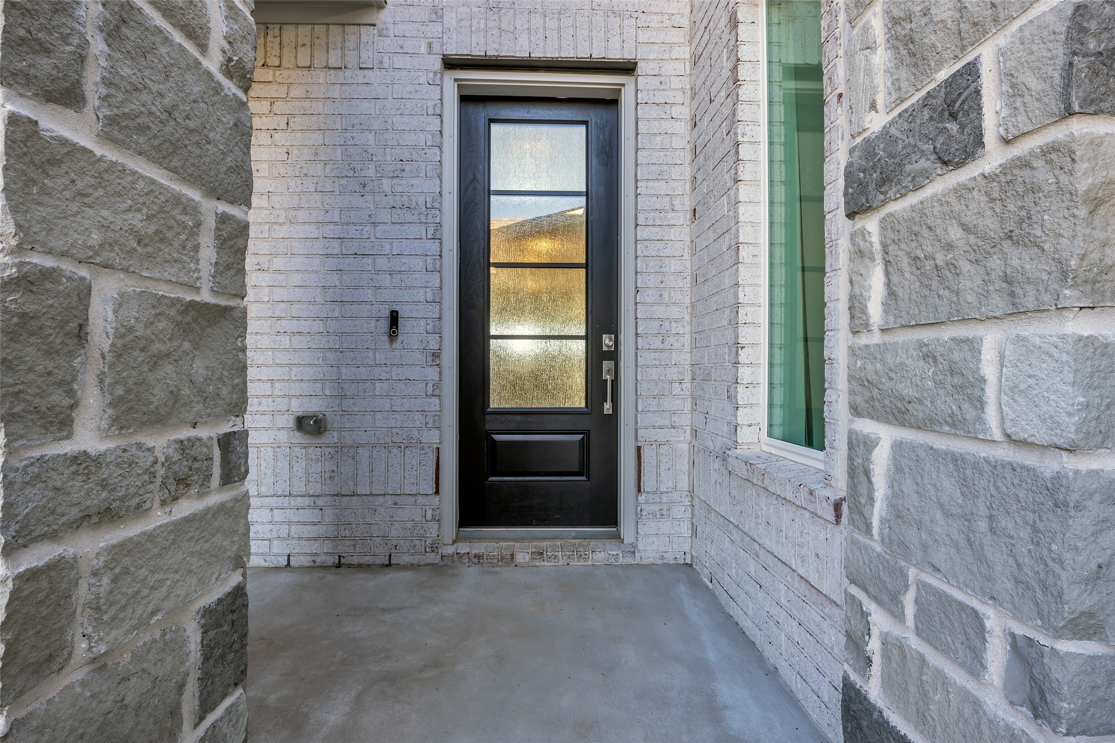 8619 Jade Hl Drive Rosharon, TX 77583 - Photo 11 of 50 Are you ready to enter the main home? Main Entry: A recessed entry framed by stone and brick creates a calm, welcoming approach. The modern front door sets a clean, understated tone before stepping inside.