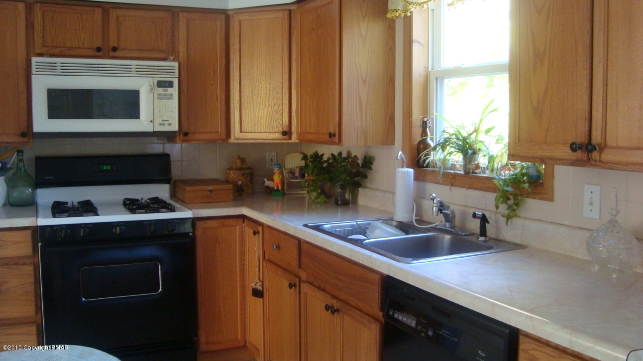2024 Romeo Road Tobyhanna, PA 18466 - Photo 5 of 8 a kitchen with stainless steel appliances a stove a sink a microwave and cabinets