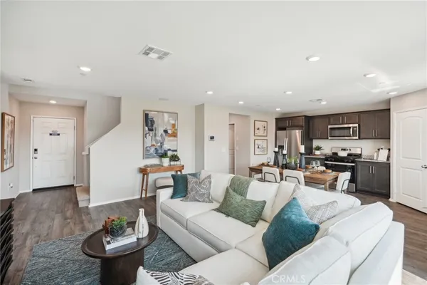 a living room with furniture kitchen view and a potted plant