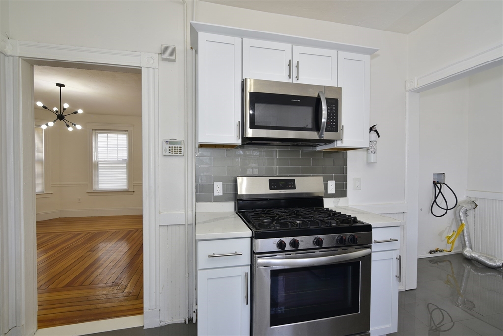 24 Rector Road, Unit 2 Boston, MA 02126 - Photo 4 of 17 a kitchen with white cabinets and appliances