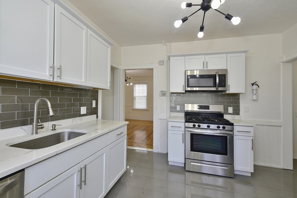 24 Rector Road, Unit 2 Boston, MA 02126 - Photo 6 of 17 a kitchen with stainless steel appliances a stove sink microwave and refrigerator