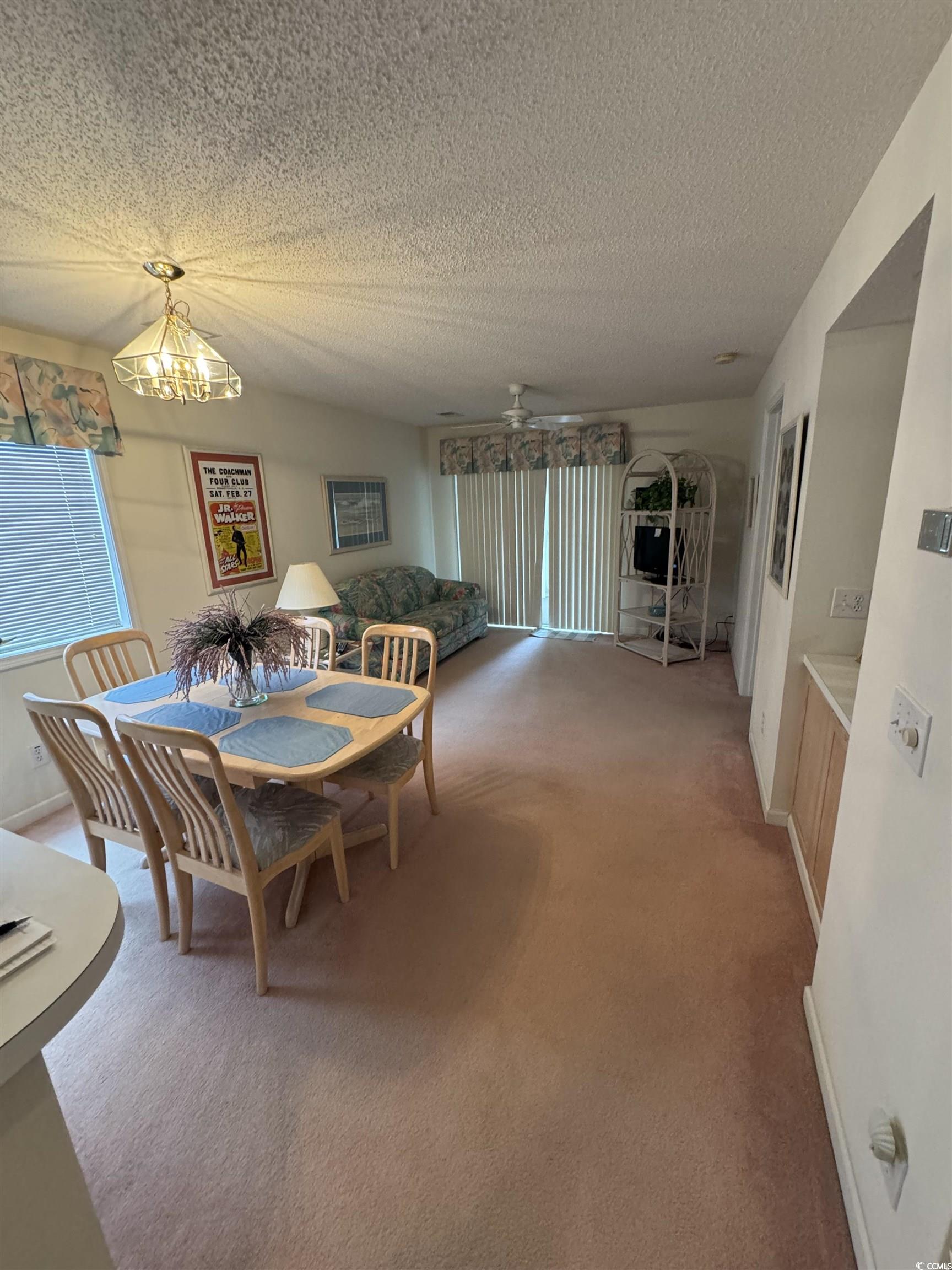 1900 Duffy Street, Unit J4 North Myrtle Beach, SC 29582 - Photo 2 of 22 Dining area with a textured ceiling, carpet flooring, a ceiling fan, and a chandelier