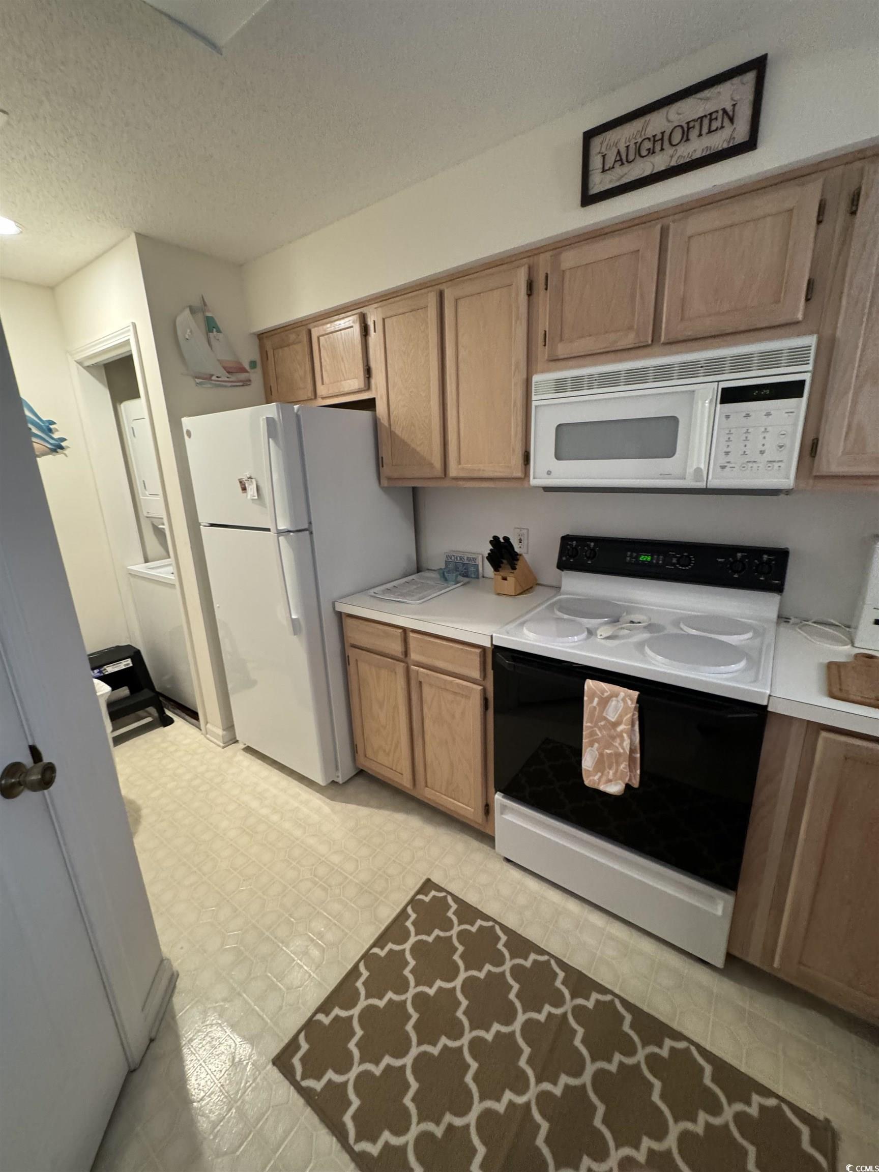 1900 Duffy Street, Unit J4 North Myrtle Beach, SC 29582 - Photo 8 of 22 Kitchen featuring white appliances, light countertops, a textured ceiling, and light flooring