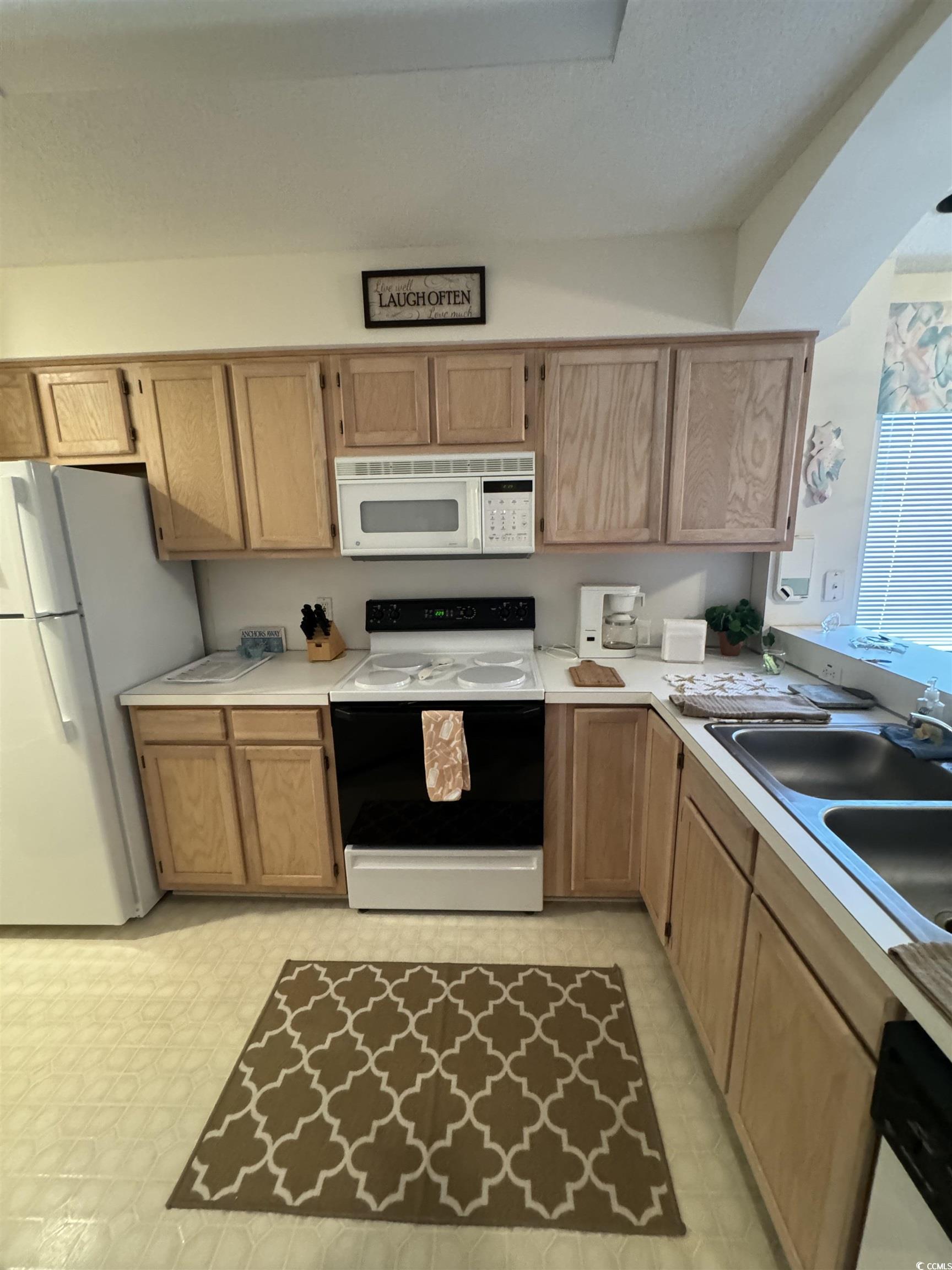 1900 Duffy Street, Unit J4 North Myrtle Beach, SC 29582 - Photo 9 of 22 Kitchen with white appliances, light countertops, and light brown cabinets