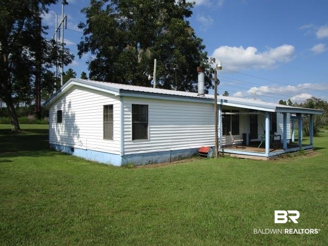 20705 Greek Cemetery Road Robertsdale, AL 36567 - Photo 4 of 25 Rear view of house with a yard, a metal roof, and crawl space
