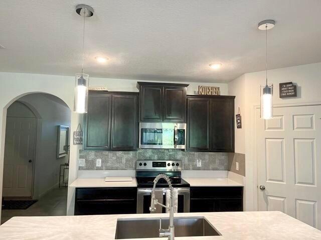 1117 Southwest Goodman Avenue Port St. Lucie, FL 34953 - Photo 7 of 18 a kitchen with stainless steel appliances kitchen island a refrigerator sink and cabinets