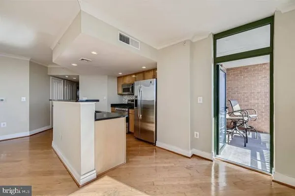 a view of a kitchen with refrigerator and wooden floor