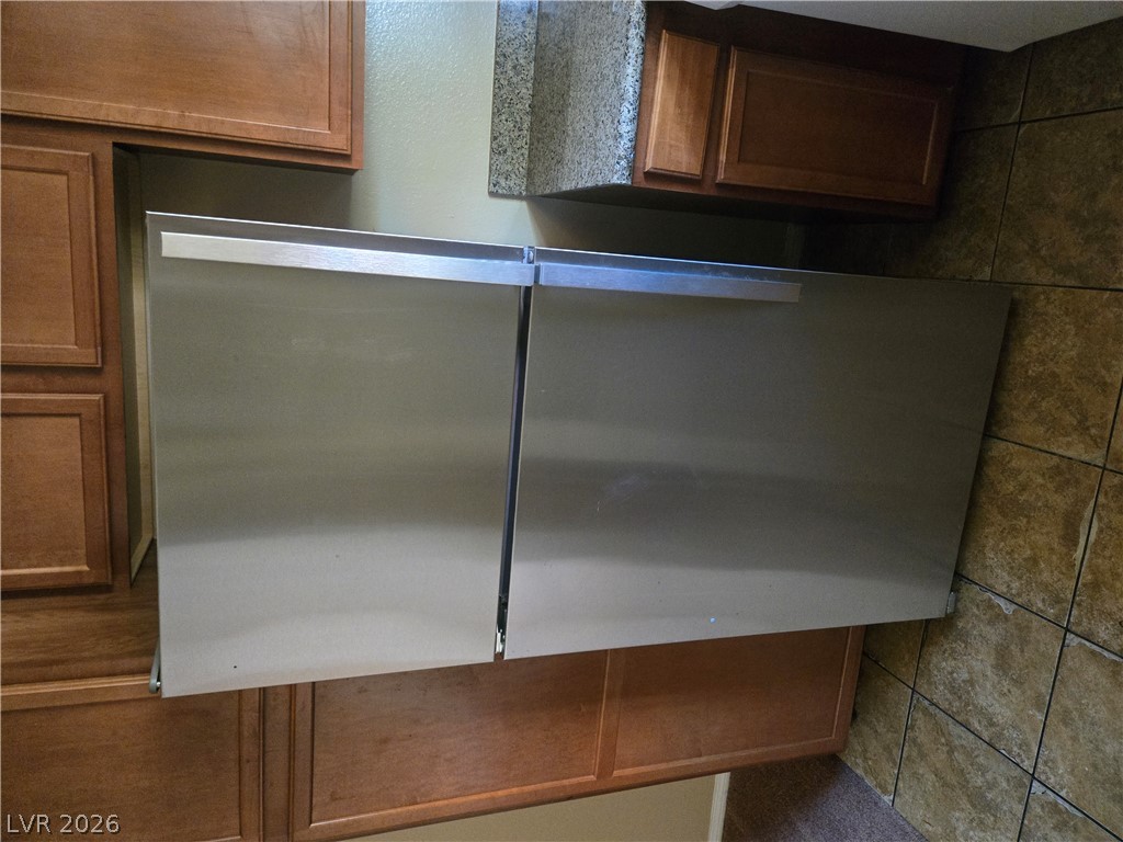 7200 West Pirates Cove Road, Unit 2047 Las Vegas, NV 89145 - Photo 6 of 17 Stainless steel dishwasher seamlessly integrated with wooden cabinetry in this functional kitchen.