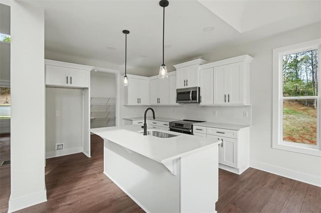 16 Altar Rock Court Cartersville, GA 30121 - Photo 11 of 52 a kitchen with stainless steel appliances granite countertop a sink a stove a refrigerator a center island with wooden floor and cabinets