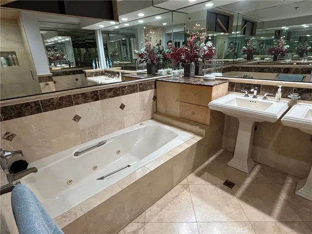 a bathroom with a tub sink and mirror