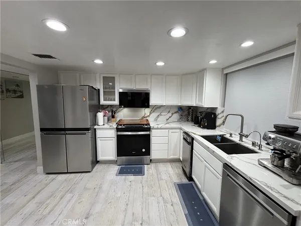 a kitchen with granite countertop appliances cabinets and a sink