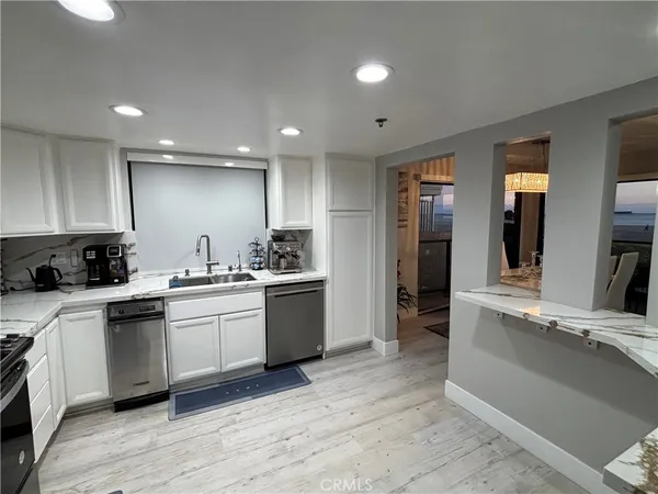 a large kitchen with stainless steel appliances kitchen island granite countertop a large cabinets a sink and a stove