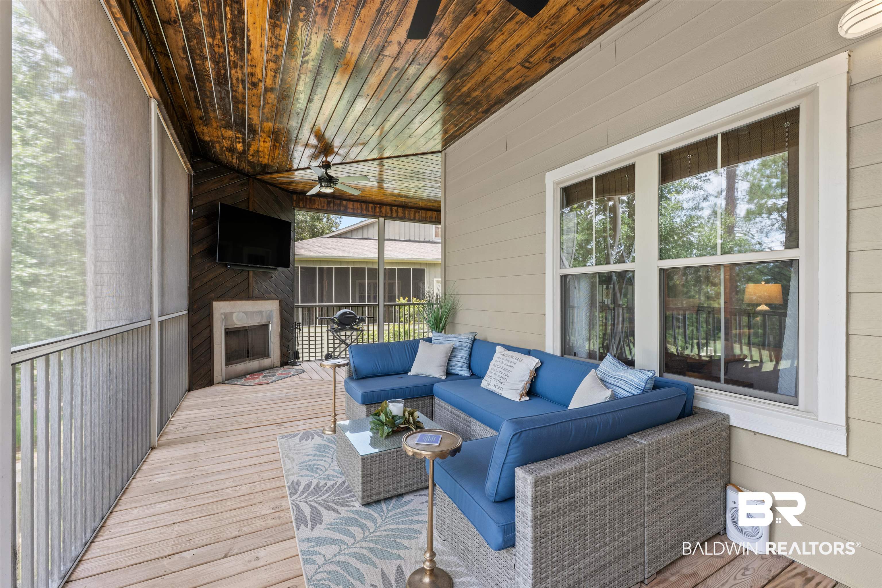 32700 Steelwood Ridge Road, Unit D Loxley, AL 36551 - Photo 27 of 41 Screened porch featuring a wood-finish ceiling, exposed beam, ceiling fan, wood-finish flooring, and built-in fireplace