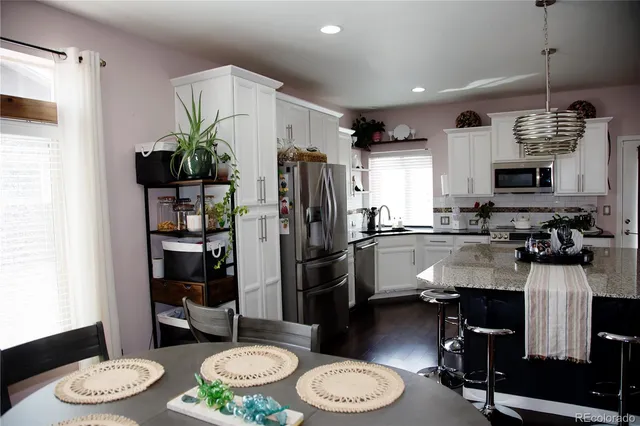 a kitchen with a table and appliances in it