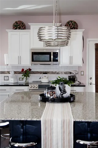 a kitchen with a stove a sink and a white cabinets